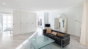 A modern living room with a glass coffee table, a black leather sofa, and a large mirror. - Spacious, bright apartment (Oberursel / Taunus)