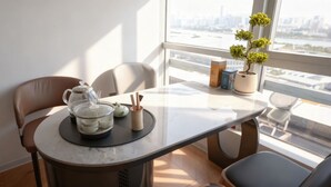 A dining table with a teapot, cups, and a small plant. - Paxin·High-Altitude City View Apartment (Canton Fair Complex Pazhou Subway Station Branch) (Guangzhou)