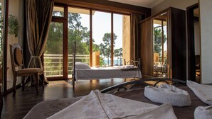A room with a bed, a chair, and a table. There are towels on the floor. - Inter (Ureki)