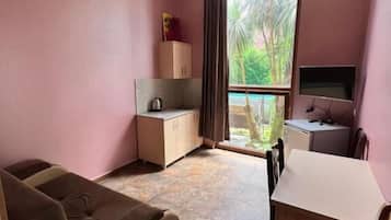 Habitación cuádruple Deluxe | Zona de estar | Una televisión