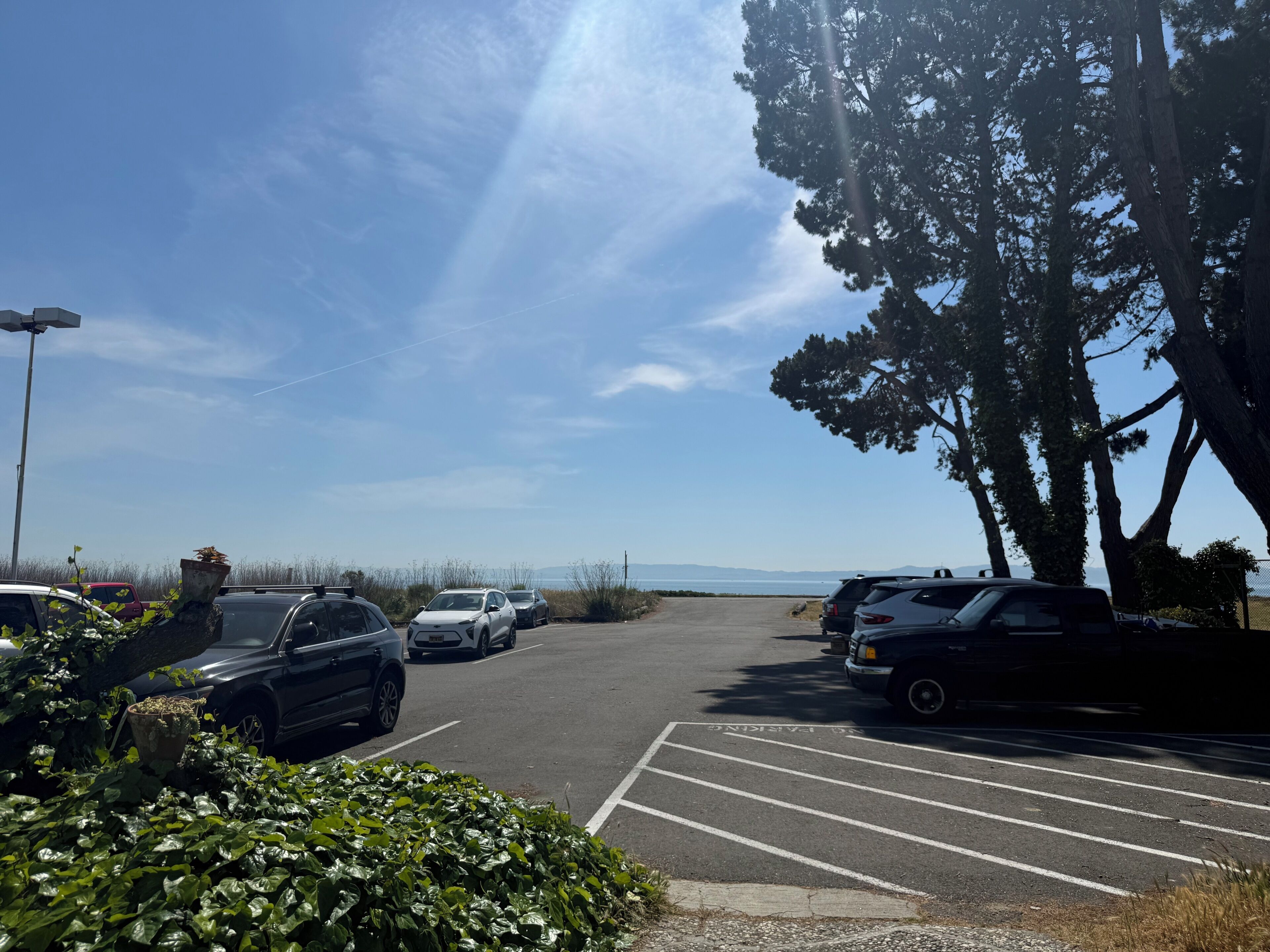 A parking lot with cars and a clear sky.