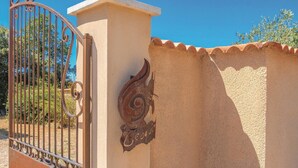A gated entrance with a decorative metal gate and a wall-mounted emblem. - Gorgeous home in Saint Didier (Saint Didier)