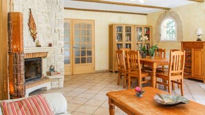 A cozy living room with a fireplace, wooden furniture, and a bookshelf. - Gorgeous home in Saint Didier (Saint Didier)