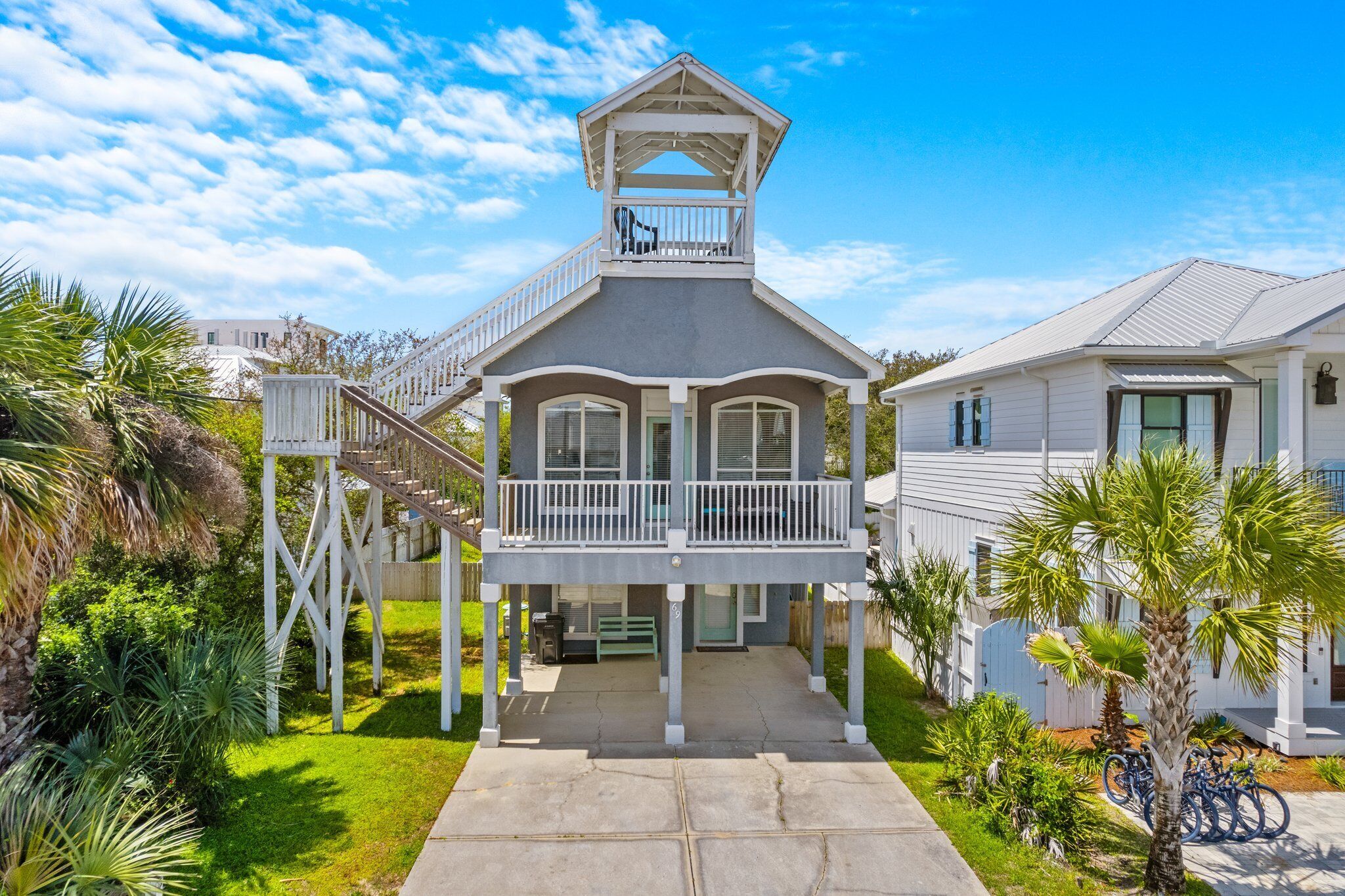 Ein zweistöckiges Haus mit Balkon, Treppe und Veranda.