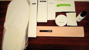 A variety of toiletries and personal care items laid out on a wooden surface. - Gaura Resort (Mohanlalganj)