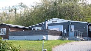 Una casa móvil con garaje, un espacio exterior cubierto y entrada pavimentada.
