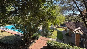 A pool area with a tiled deck, surrounded by lush greenery and trees. - Stunning  villa with private pool, WIFI, A/C, TV, veranda, pets allowed and panoramic view (Torre)
