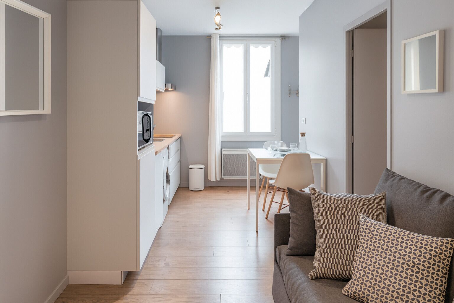 A modern apartment with a kitchen, dining area, and living room.