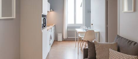 A modern apartment with a kitchen, dining area, and living room.