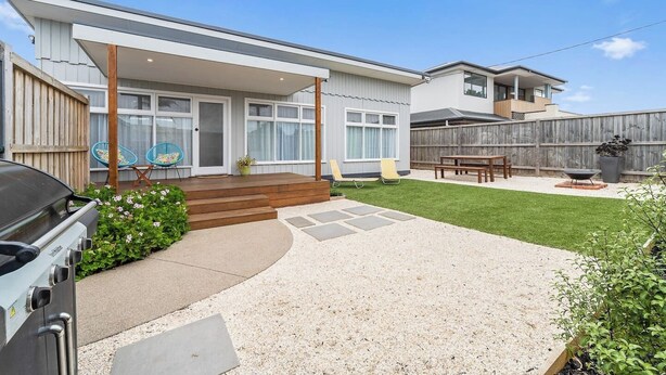 A residential backyard with a covered patio, a barbecue grill, a wooden deck, and a fenced area. - The Shamrock - 700m to the Beach (Rosebud)