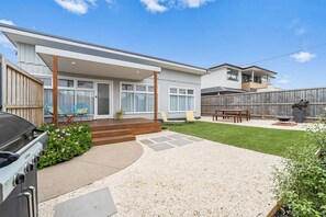 A residential backyard with a covered patio, a barbecue grill, a wooden deck, and a fenced area. - The Shamrock - 700m to the Beach (Rosebud)