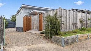 A modern building with a wooden fence, a gravel driveway, and a small garden area. - The Shamrock - 700m to the Beach (Rosebud)