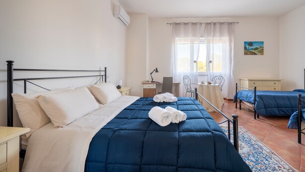 A hotel room with a bed, a desk, a chair, a small table, and a window with curtains. - Villa 'Tubola' with Shared Pool, Wi-Fi and Air Conditioning (Lizzanello)