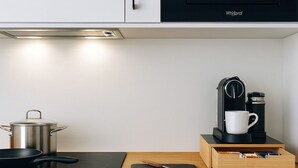 A modern kitchen with a black microwave, a coffee maker, a pot on the stove, and a wooden countertop. - New Tiny House - cozy, private, family-friendly! (Hessisch Lichtenau)