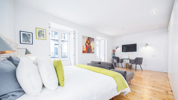 Une chambre à coucher moderne avec un grand lit, un bureau et un téléviseur.