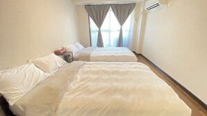 A hotel room with two beds, a small table, and a window with curtains. - 30sec walk to Tsutenkaku/1 stop to Namba Sta./AH48 (Ebisu Higashi Naniwa-Ward,Osaka City)