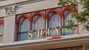 A building facade with large arched windows and a prominent sign that reads 'SAVINY BY M VILLAGE'. - Savvy by M Village Hai Ba Trung, a brand of Modern Village Lifestyle (Ho Chi Minh City)