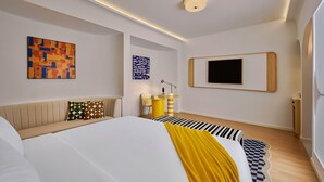 A modern bedroom with a large bed, a flat-screen TV, and abstract art on the walls. - Savvy by M Village Hai Ba Trung, a brand of Modern Village Lifestyle (Ho Chi Minh City)