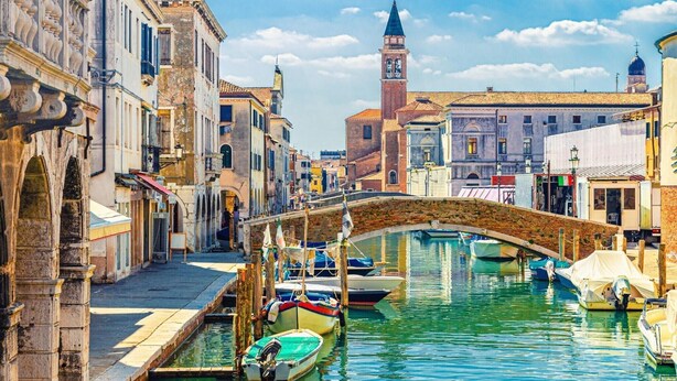 A canal with boats, historic buildings, and a prominent tower. - Pleasant apartment in Rosolina Mare with balcony (Rosolina Mare (RO))