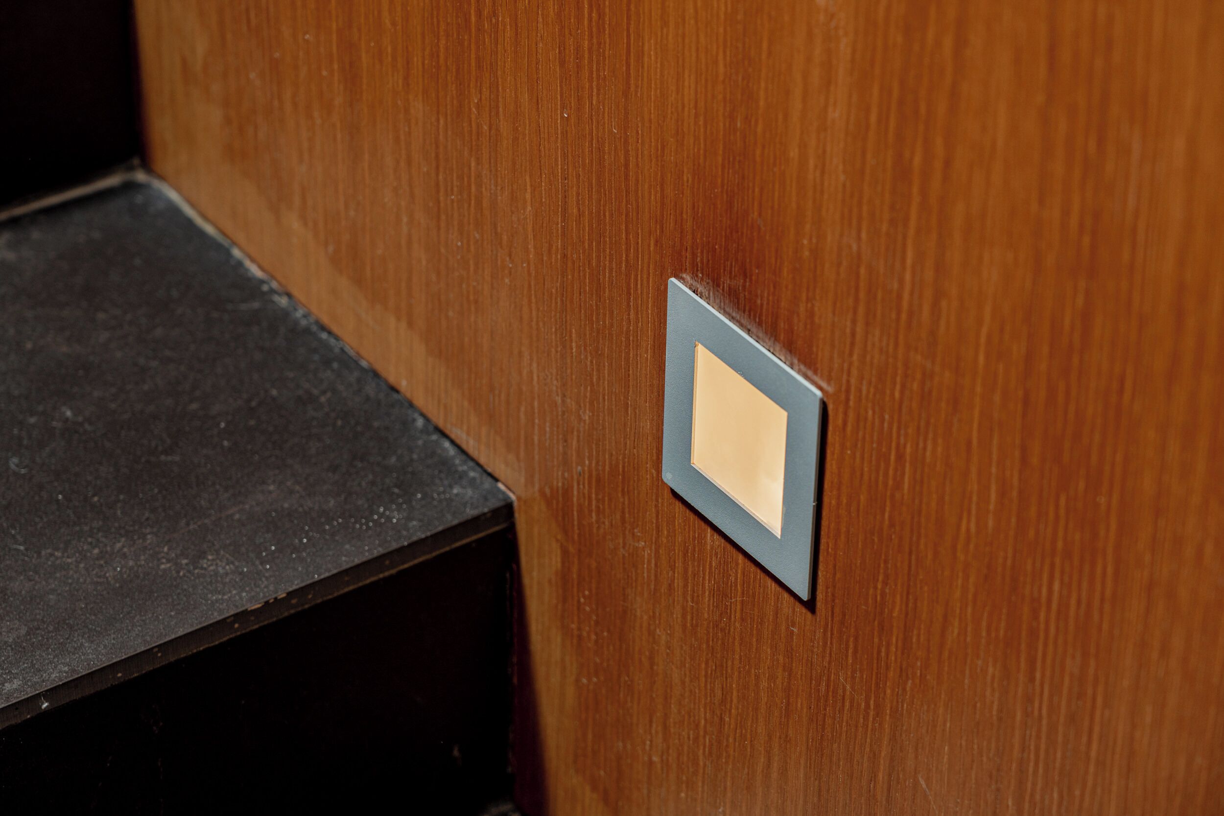 A wooden door with a small, square, light-colored label.