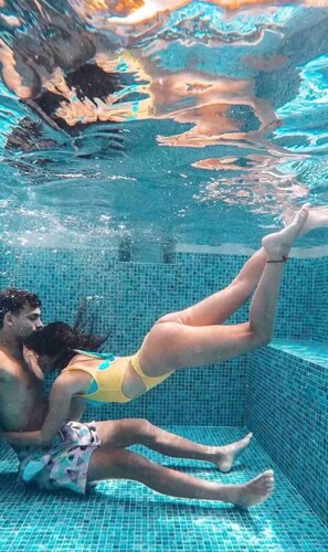 En person som flyter i en pool med kakelbeklädda väggar.
