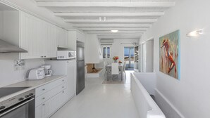A modern kitchen with white cabinetry, a stainless steel refrigerator, and a built-in oven. - My Rental Homes - Villa Cassandra, less than 2 km from the beach with pool (Mykonos)
