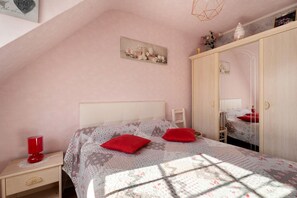 A bedroom with a bed, a nightstand, a wardrobe, and a wall-mounted picture. - Bed and Breakfast 'Reine' with Shared Terrace and Wi-Fi (Cancale)