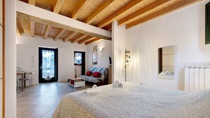 Une chambre à coucher avec un lit, un bureau et une chaise, une fenêtre et une porte.