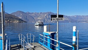 Une jetée sur laquelle est affiché un panneau indiquant « SALE MARASINO 1 », avec un bateau en arrière-plan.