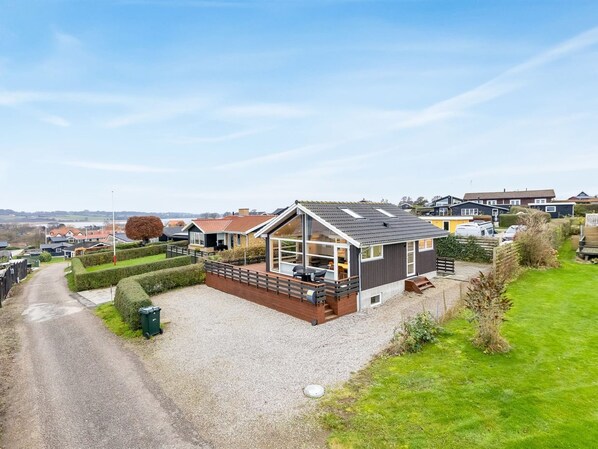 A modern house with a sloped roof, large windows, and a gravel driveway. - "Bundi" - 25m from the sea by Interhome (Hejls)