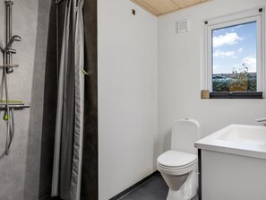 A small, modern bathroom with a shower, toilet, and sink. - "Bundi" - 25m from the sea by Interhome (Hejls)