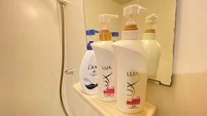 A bathroom shelf with three bottles of hair care products. - 30-second walk from Tsutenkaku / 1 stop to Namba Station / 4 beds (Ebisu Higashi Naniwa-Ward,Osaka City)