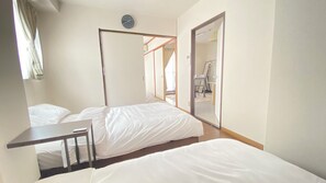 A hotel room with two beds, a desk, and a large mirror. - 30-second walk from Tsutenkaku / 1 stop to Namba Station / 4 beds (Ebisu Higashi Naniwa-Ward,Osaka City)