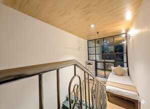 A bedroom with a bed, a window with a view, a staircase, and a ceiling fan. - Alwar Villa - Gagal Home (Alwar)