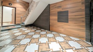 Un interior moderno con suelo de diseño geométrico, una escalera y paredes de madera.