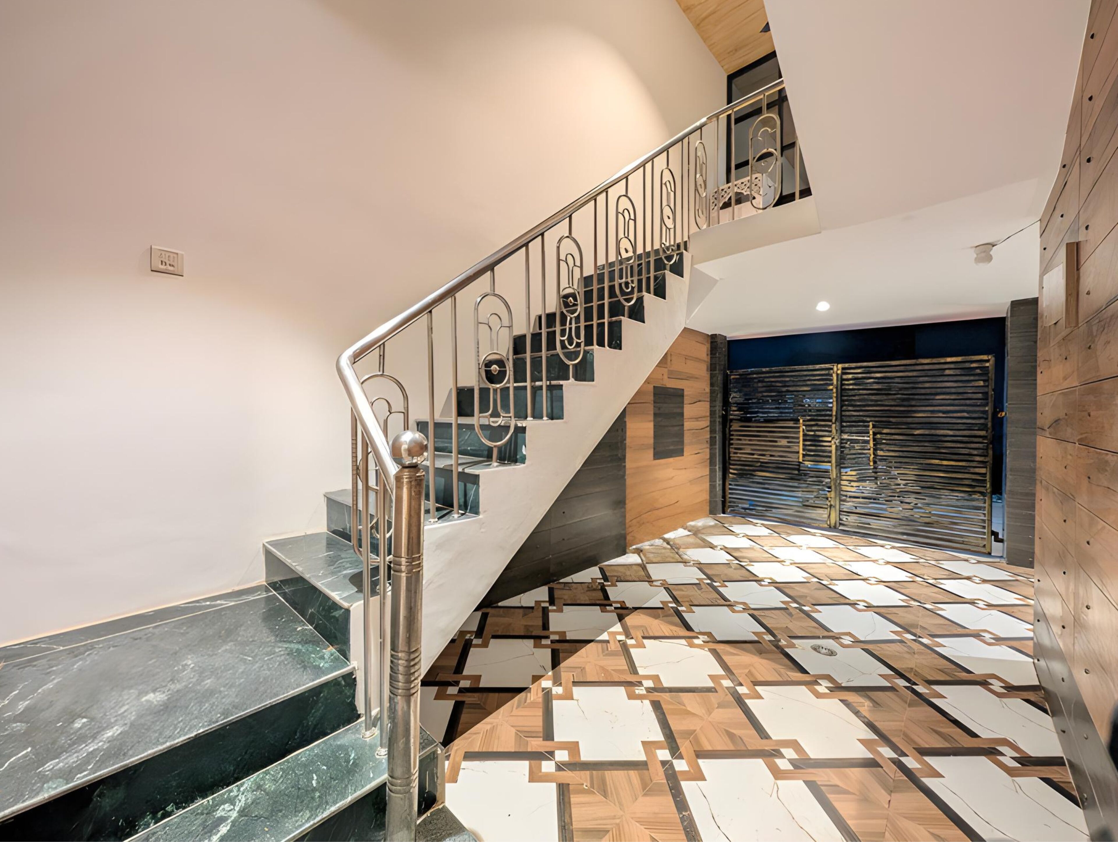 Una escalera moderna con piso de diseño geométrico y barandilla de metal.