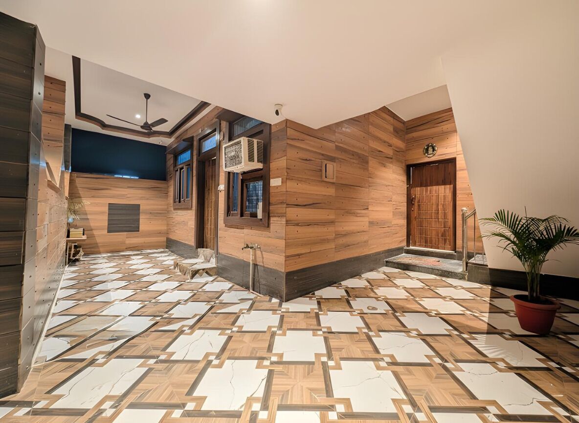 A modern interior with a geometric patterned floor, wooden walls, and a ceiling fan.