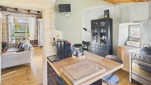 A cozy kitchen with a wooden ceiling, a black cabinet with glass doors, and a stove. - Valley View – Large house for 10 – Pool (Les Eyzies-de-Tayac-Sireuil)