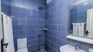 A bathroom with blue tiles, a toilet, a sink, and a mirror. - Single Room with Sea View – Aquatic Village, Red Sea Resort (Red Sea Governorate)
