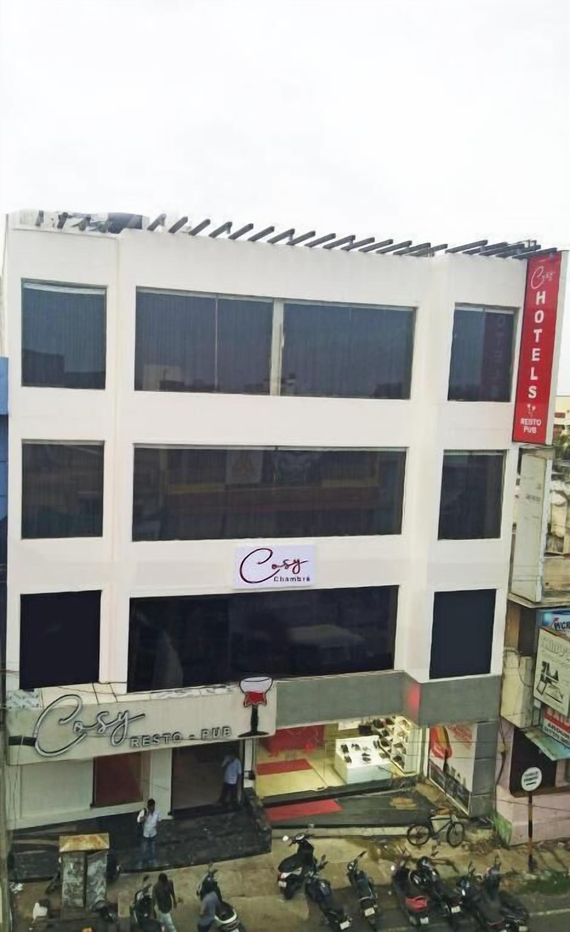 A multi-story building with a prominent 'Cosy' sign on the facade, indicating a hotel or similar establishment.