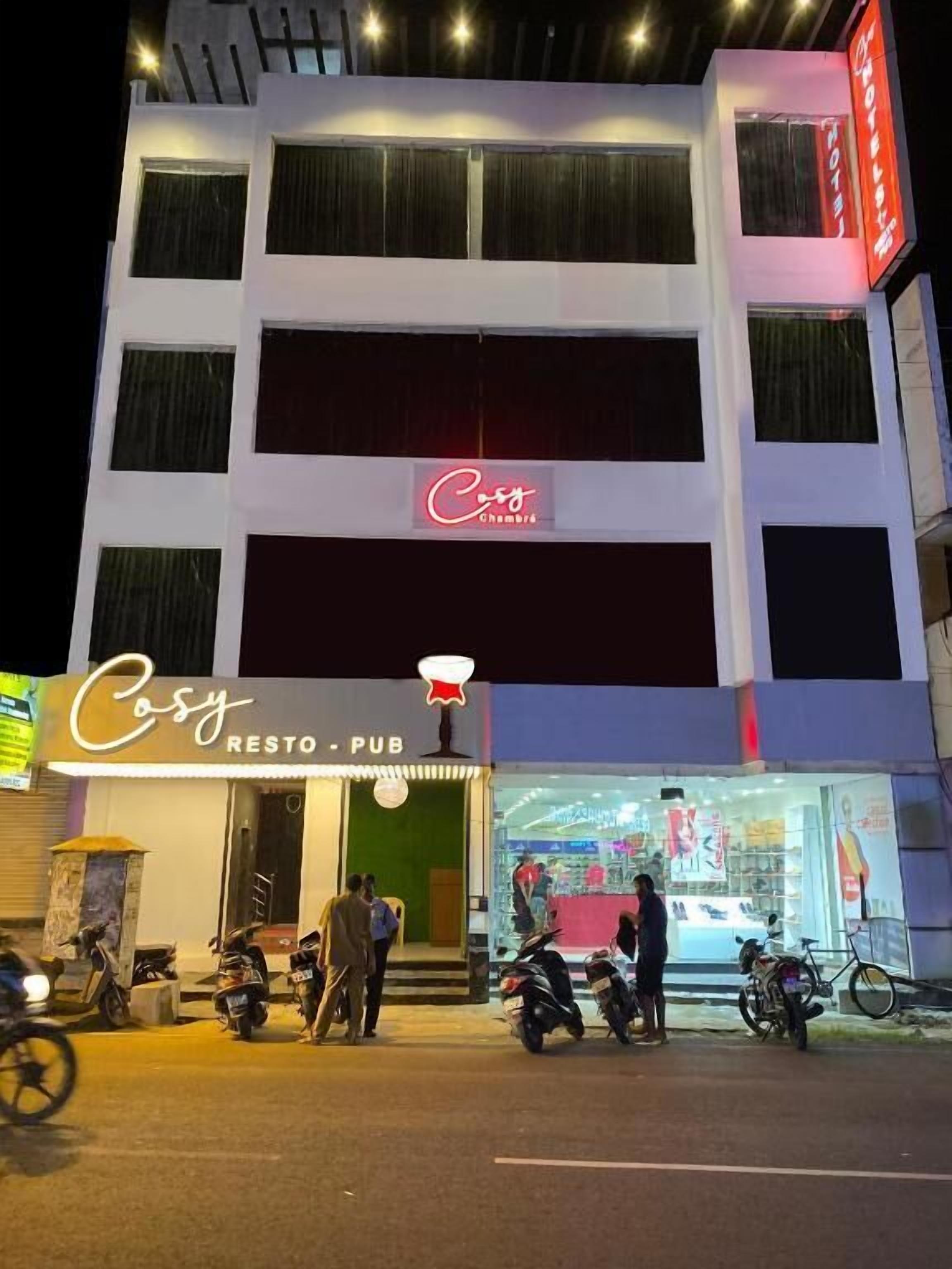 Egy épület, melynek a földszinti részén „Casy RESTO – PUB” feliratú tábla található, jelezve, hogy itt étterem és söröző is van. Kint néhány motor parkol, és az bejárat közelében néhány ember is látható.