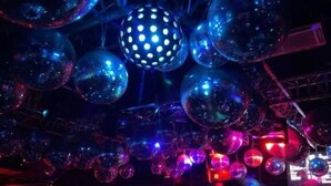 Un lieu bondé, avec de nombreuses boules à facettes suspendues au plafond, créant une ambiance animée.
