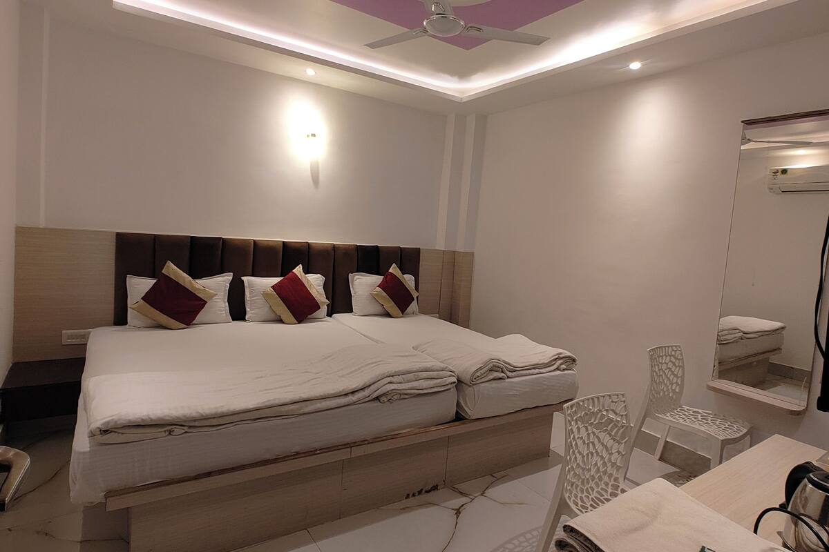 A modern bedroom with a bed, a ceiling fan, a nightstand, and a mirror.