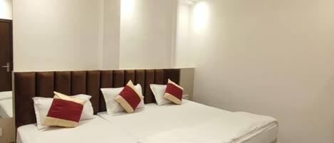 A modern bedroom with a large bed, two ceiling fans, and a red and white color scheme.