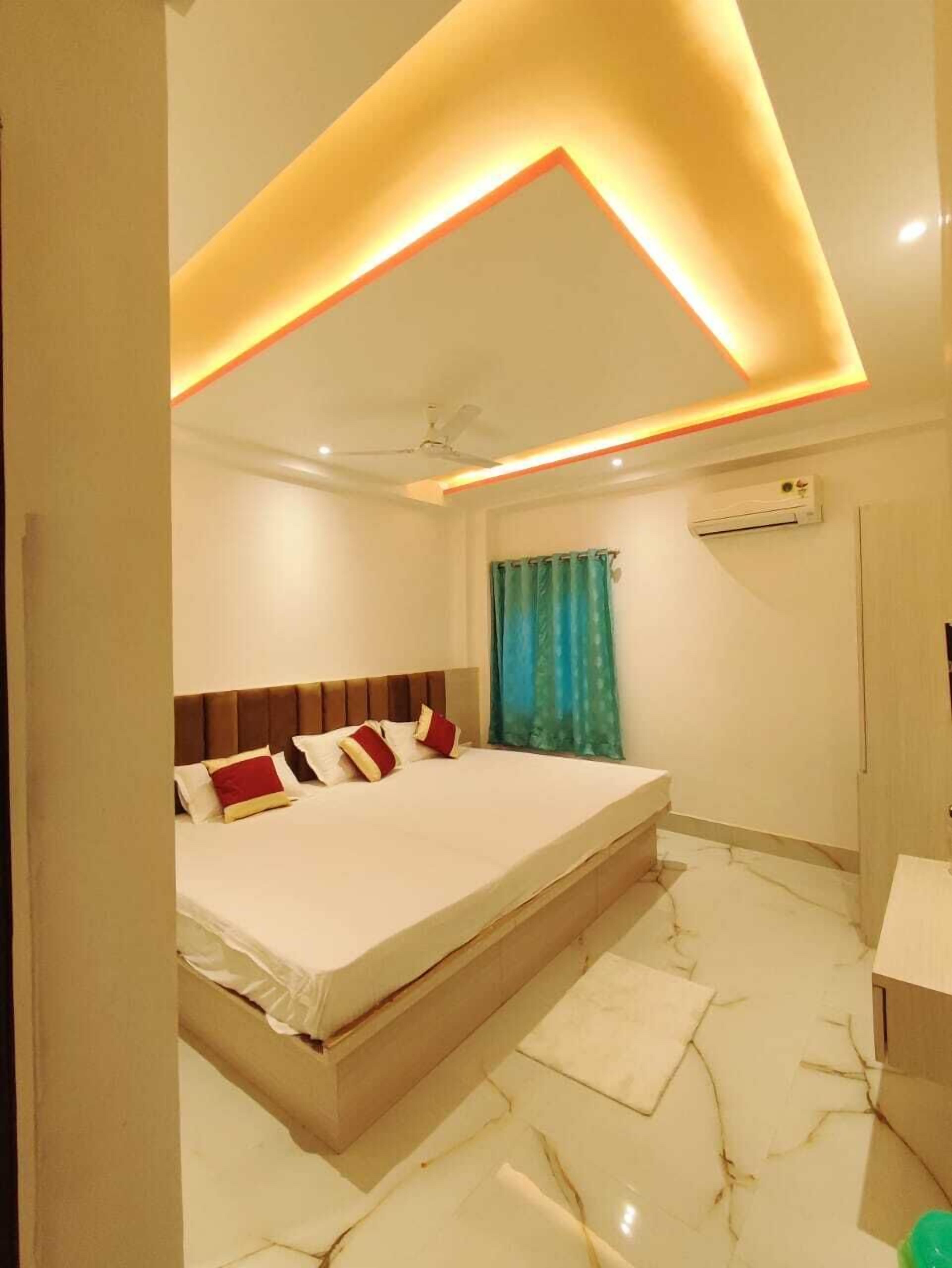 A modern bedroom with a bed, a ceiling fan, and an air conditioning unit.