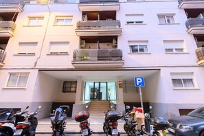 Ein mehrstöckiges Wohngebäude mit Parkplatz davor.