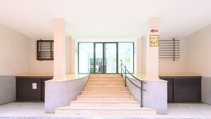 A staircase leading to a glass door entrance, with a metal railing and a sign indicating a 5-year lease. - Bright one-bedroom flat with excellent amenities (Madrid)