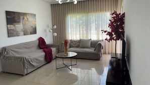 A modern living room with a sofa, a coffee table, and a decorative vase.
