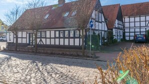 Un bâtiment traditionnel à colombages, avec une rue pavée devant.