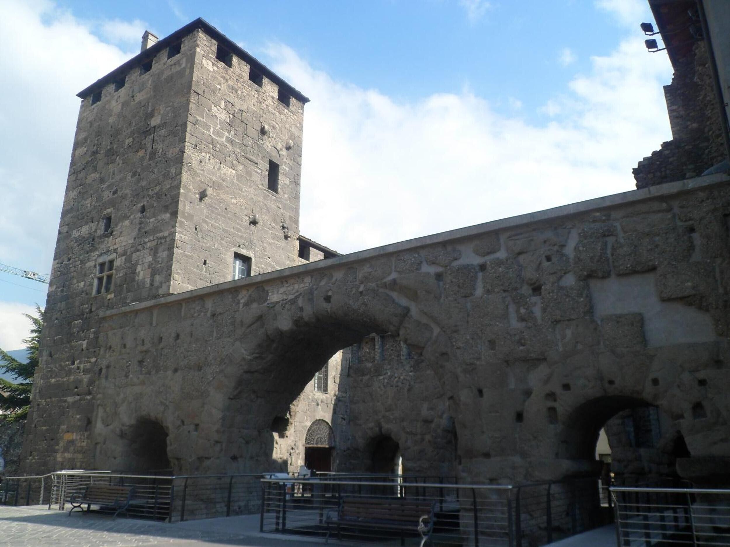A stone bridge with an arch and a tower.